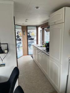 a kitchen with white cabinets and a counter top at Chalet Inn Ameland inclusief Fietsen, Zee en Strand op loopafstand! in Buren