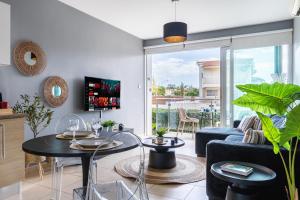 a living room with a couch and tables and a tv at 1BR Apt. next to Coralli Beach Protaras in Paralimni