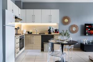 a kitchen with white cabinets and a small table at 1BR Apt. next to Coralli Beach Protaras in Paralimni
