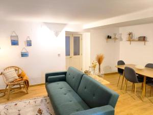 a living room with a blue couch and a table at O Refúgio do Pim in Horta