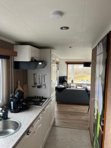 an rv kitchen with a sink and a stove at Chalet Inn Ameland inclusief Fietsen, Zee en Strand op loopafstand! in Buren +21 photos