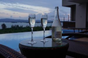 two wine glasses and a bottle on a table at relax kouri villa Rekrrr in Nakijin