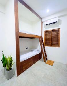 a room with a bunk bed with a ladder at Trinco Beach Bunks in Trincomalee +8 photos