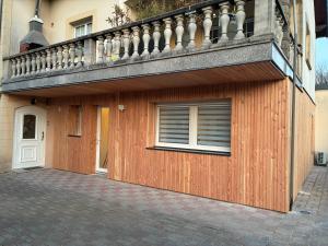 a wooden building with a balcony on top of it at Cottage des Lacs in Puttelange-aux-Lacs