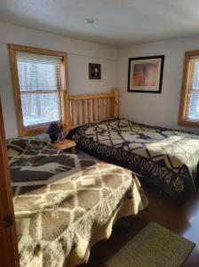 a bedroom with two beds and two windows at BearAss Lodge in Hayward +5 photos