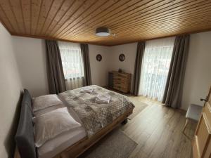 a bedroom with a bed and a wooden ceiling at Haus Monica in Bodenmais