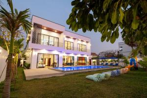 a large house with a swimming pool in front of it at Blanc Smith Private Villa in Siem Reap