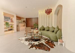 a living room with a green couch and a table at Casa Charlie Hotel in Manila