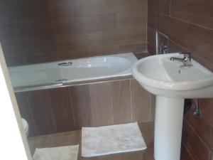 a bathroom with a sink and a bath tub at Harnham Mountain Lodge in Elsteg +49 photos