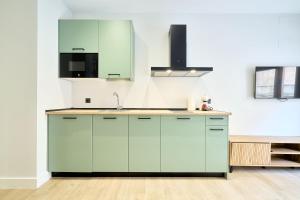a kitchen with green cabinets and a sink at Rosario 32 by keyhom in Salamanca