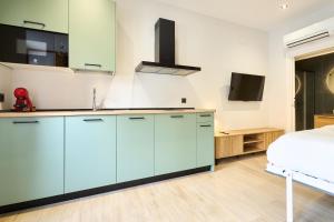 a kitchen with blue cabinets and a bed at Rosario 32 by keyhom in Salamanca