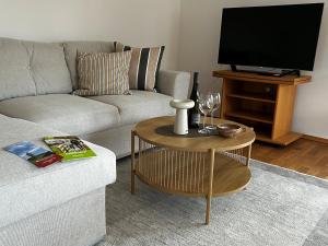 a living room with a couch and a table with a tv at Ferienhaus Weidblick in Westerstede