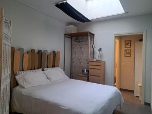 a bedroom with a white bed with a wooden headboard at Il TRE del TRENTA in Turin