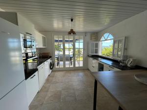 a kitchen with white cabinets and a counter top at Domaine Madinina Dream in Sainte-Luce