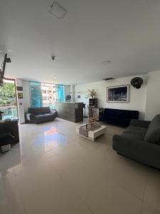 a large living room with couches and a table at Hotel Suites Caribe in Barranquilla