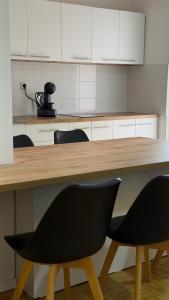 a kitchen with a wooden table and two chairs at Apartment Struga Orion in Struga