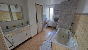 a bathroom with two sinks and a bath tub at Gîte Eugénie in Aspach-le-Bas
