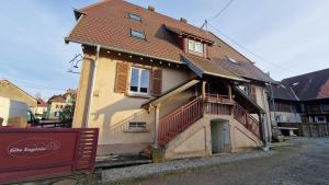 a small house with a porch and a balcony at Gîte Eugénie in Aspach-le-Bas