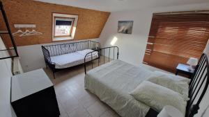 a bedroom with two beds and a window at Gîte Eugénie in Aspach-le-Bas