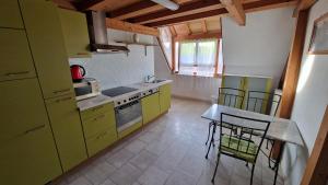 a kitchen with green cabinets and a table and chairs at Gîte Eugénie in Aspach-le-Bas