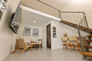 a dining room with a staircase and a table and chairs at Casa Charlie Hotel in Manila