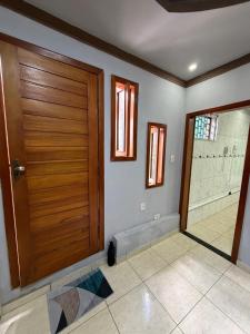 a bathroom with a wooden door and a shower at Casa Ibirapuera in Vitória da Conquista