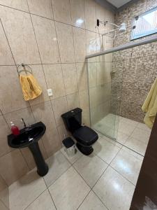 a bathroom with a shower and a toilet and a sink at Casa Ibirapuera in Vitória da Conquista