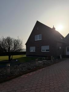 a house with a brick driveway in front of it at Ferienwohnung Weitblick in Großheide