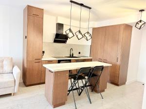 a kitchen with wooden cabinets and a kitchen island with a sink at Drahan Apartment 38 in Radom +14 photos