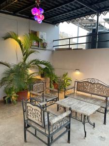 two benches and a table in a room with plants at Myra Villa Kolhapur Entire Private Home in Kolhapur