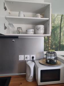 a kitchen with a microwave and a bowl on top of it at Studio Zen Miramas in Miramas