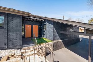 a brick house with orange doors and a courtyard at The Orange Door - Two Homes - Plunge Pool in Austin +47 photos