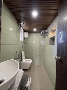 a bathroom with a white toilet and a sink at Myra Villa Kolhapur Entire Private Home in Kolhapur +9 photos