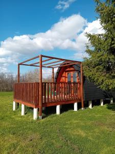 a wooden house with a deck in the grass at L'Escapade dans les Prés in Les Pégués +23 photos