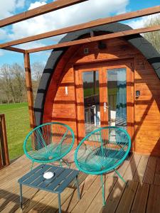a cabin with two chairs and a table on a deck at L'Escapade dans les Prés in Les Pégués