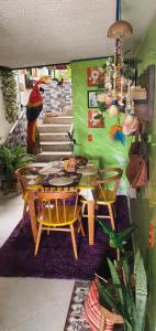 a dining room with a table and chairs and a painting at Antigua Hostal in Bucaramanga