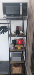 a microwave oven sitting on top of a shelf at Biesbosch Bed & Breakfast Werkendam in Werkendam +5 photos