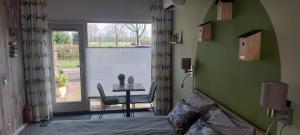 a bedroom with a bed and a table and a window at Biesbosch Bed & Breakfast Werkendam in Werkendam