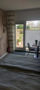 a living room with a table and a window at Biesbosch Bed & Breakfast Werkendam in Werkendam