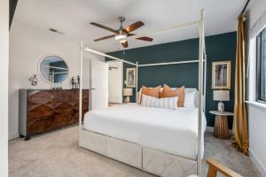 a bedroom with a white bed and a blue wall at The Orange Door - Unit A - Heated Plunge Pool in Austin