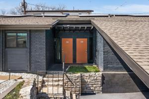 a brick house with an orange door and stairs at The Orange Door - Unit A - Heated Plunge Pool in Austin +25 photos