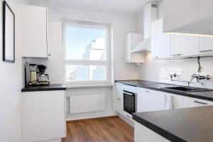 a kitchen with white cabinets and a window at Helmi Pori Centrum in Pori +5 photos