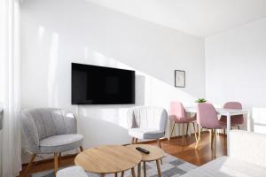 a living room with a table and chairs and a tv at Helmi Pori Centrum in Pori