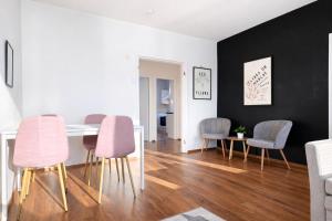 a dining room with pink chairs and a table at Helmi Pori Centrum in Pori
