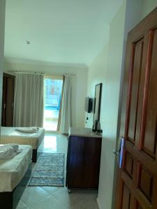 a hotel room with two beds and a door at sharks bay oasis aqua park in Sharm El Sheikh
