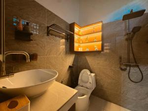 a bathroom with a white sink and a toilet at Yokohama Premium House in Batam Center +27 photos