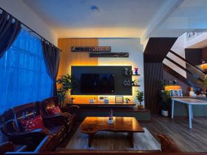 a living room with a couch and a tv at Yokohama Premium House in Batam Center