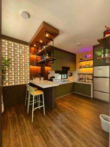 a kitchen with green cabinets and a counter with a stool at Yokohama Premium House in Batam Center