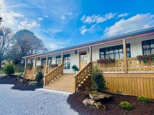 a house with a wooden railing and a deck at Sommer House Inn-Garden Room in Jasper