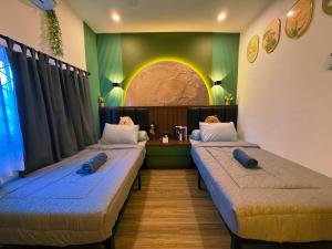 two beds in a room with a arched window at Yokohama Premium House in Batam Center